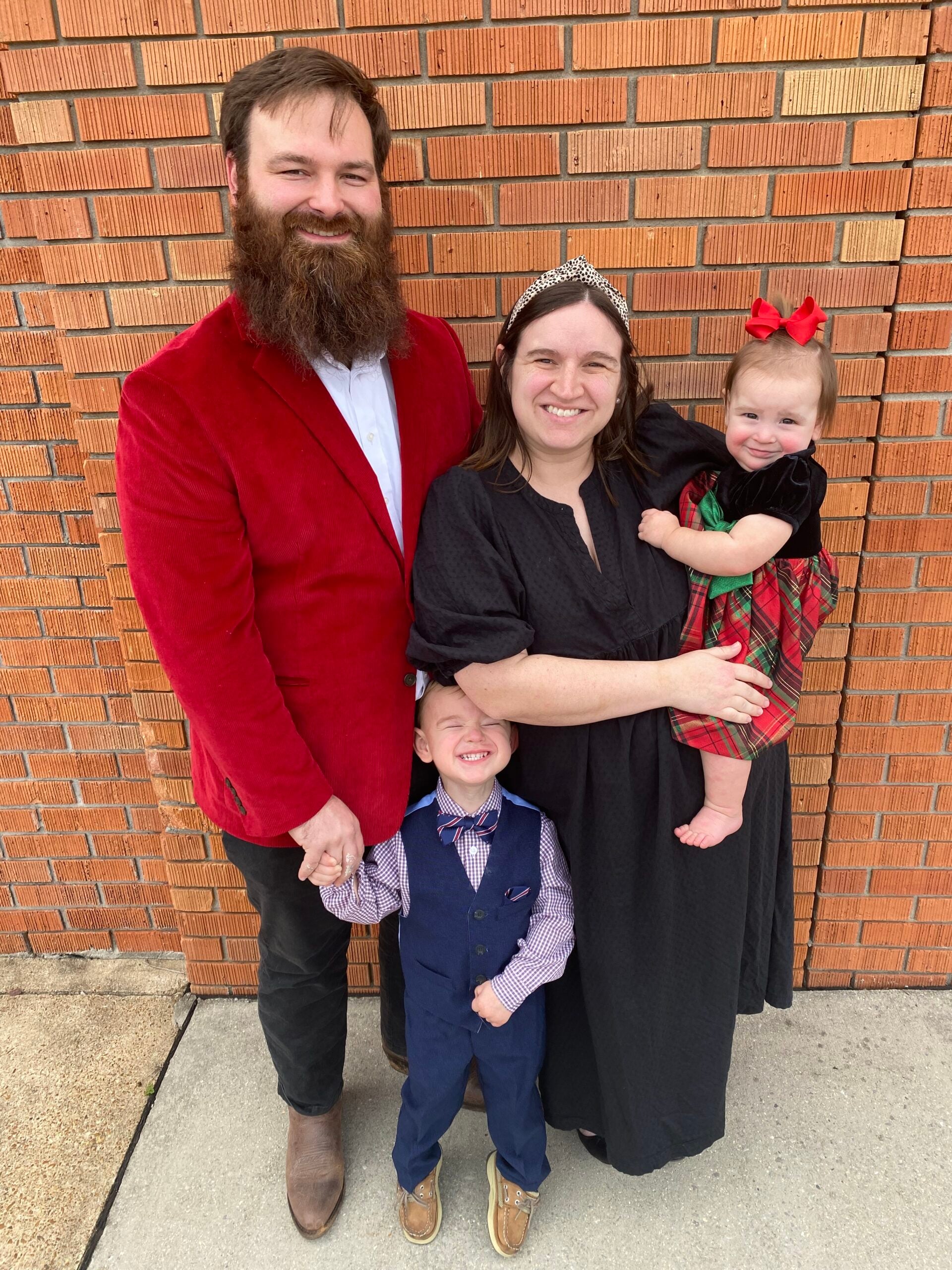 l-r Nick, Carter, Margaret and Wanda Berryman pose together in front of a brick wall.