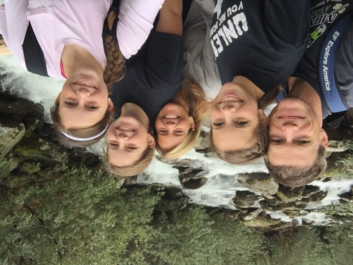 Left, T. Kirke Adams poses with his wife and three daughters in front of a creek, rocks, trees and white water