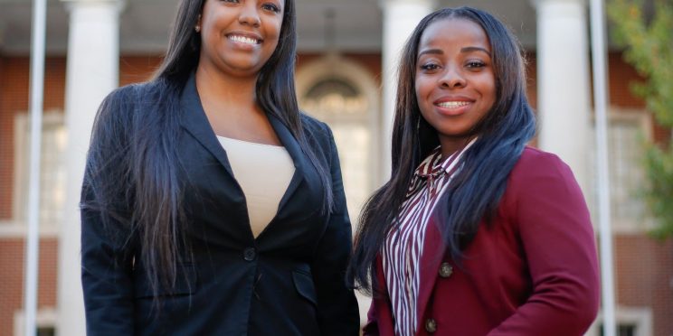 Faulkner Law graduate Aigner Kolom, left poses with Faulkner Law student Iesha Brooks in front of Montgomery City Hall.