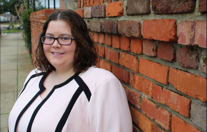 Lauren James stands in front of a brick wall.